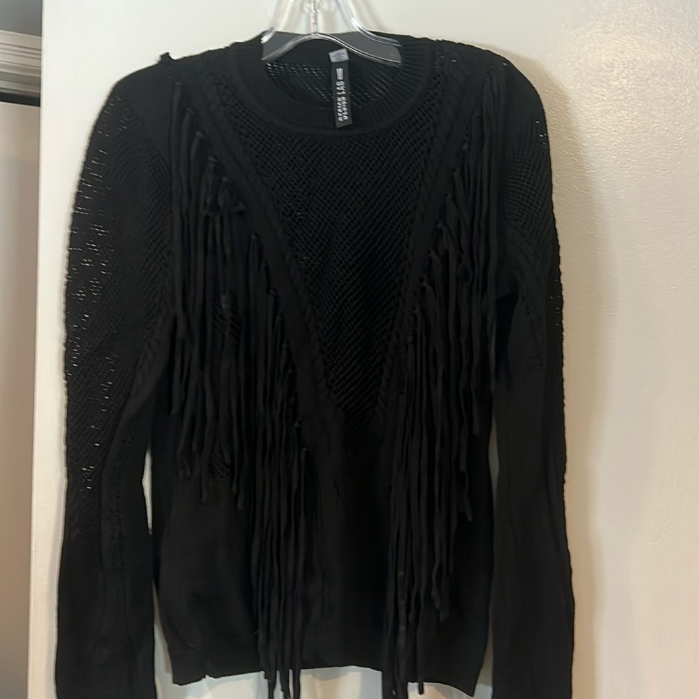 Black sweater with fringes.